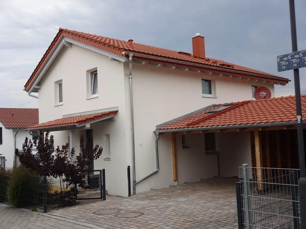 Einfamilienhaus mit frisch gestrichener Fassade und Carport