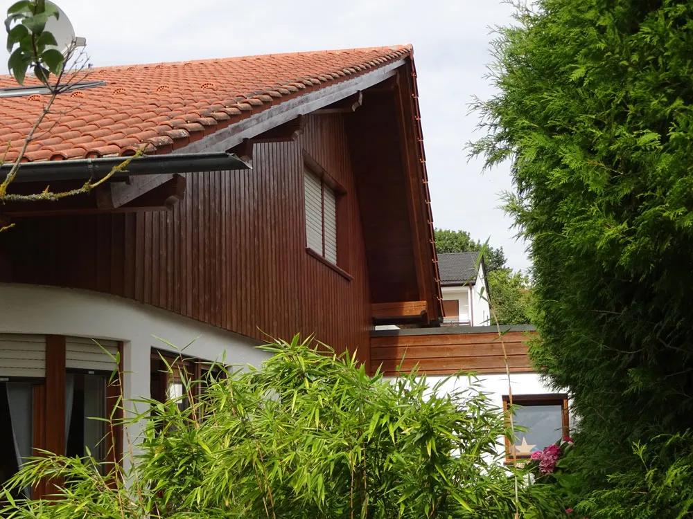 Frisch lasierte Holzverkleidung am Giebel eines Wohnhauses bei Freising